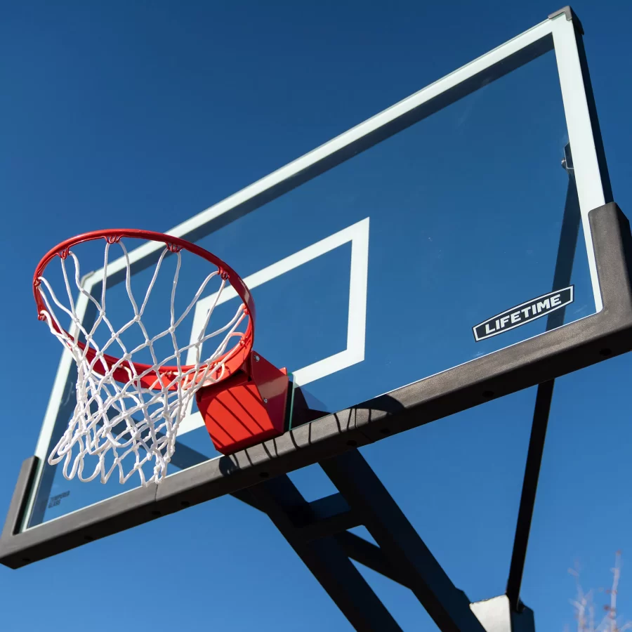 Basketball hoop with net and backboard under clear blue sky, representing residential basketball court options by Cornerstone Courts in Sydney.